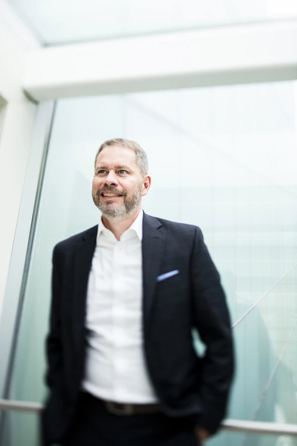 Frédéric Gascon, vice-président du conseil d'administration du Musée national des beaux-arts du Québec, photographié à l'intérieur du Musée, devant un mur vitré.
