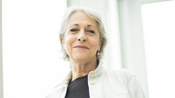 Hélène Dufresne, membre du comité des ressources humaines du conseil d'administration du Musée national des beaux-arts du Québec, photographié à l'intérieur du Musée, devant une porte blanche et de verre.