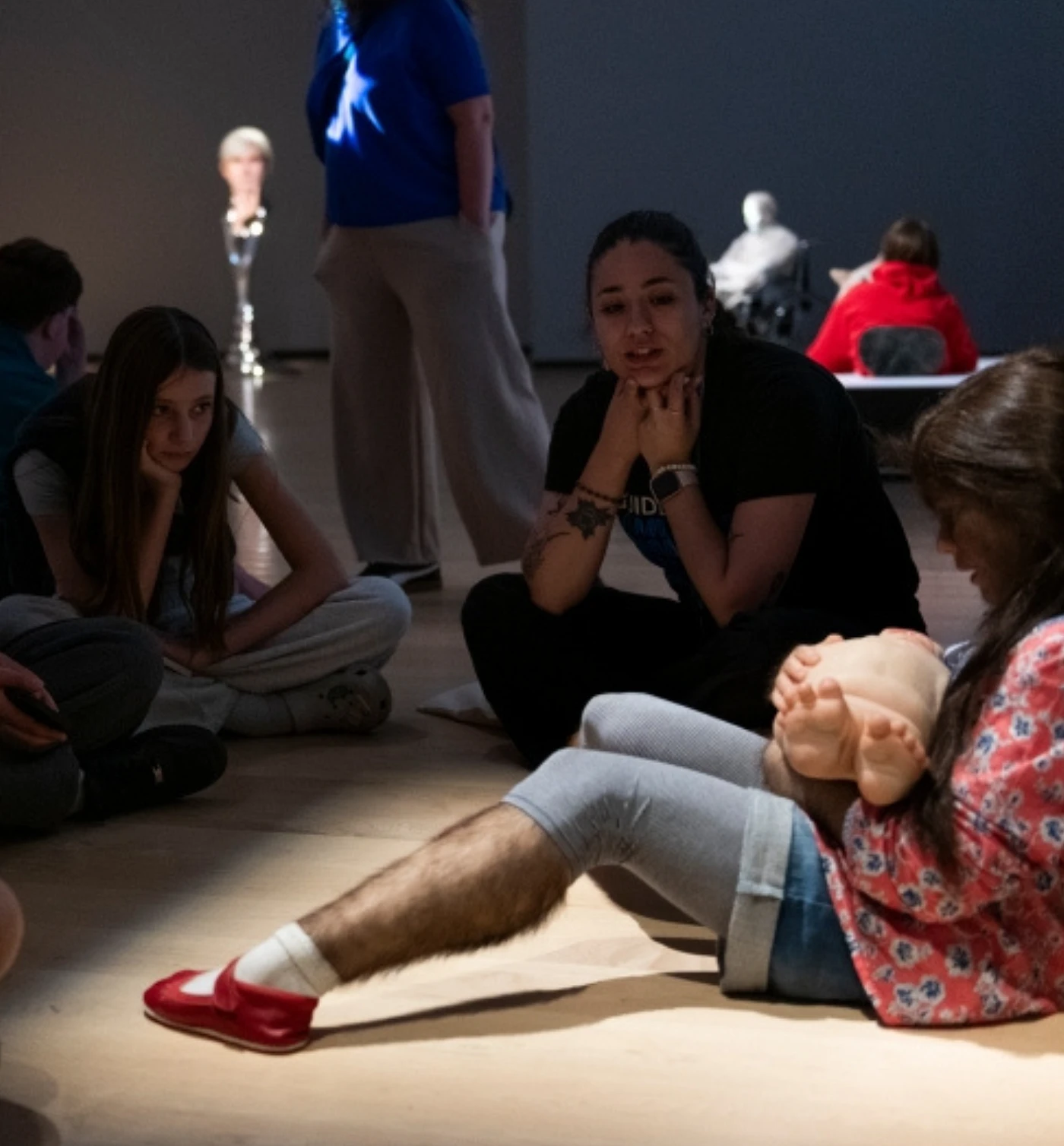 Un groupe d'élève du secondaire devant l'oeuvre de Patricia Piccinini, La consolatrice.