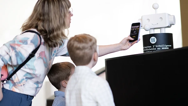 Une famille scan le robot du musee