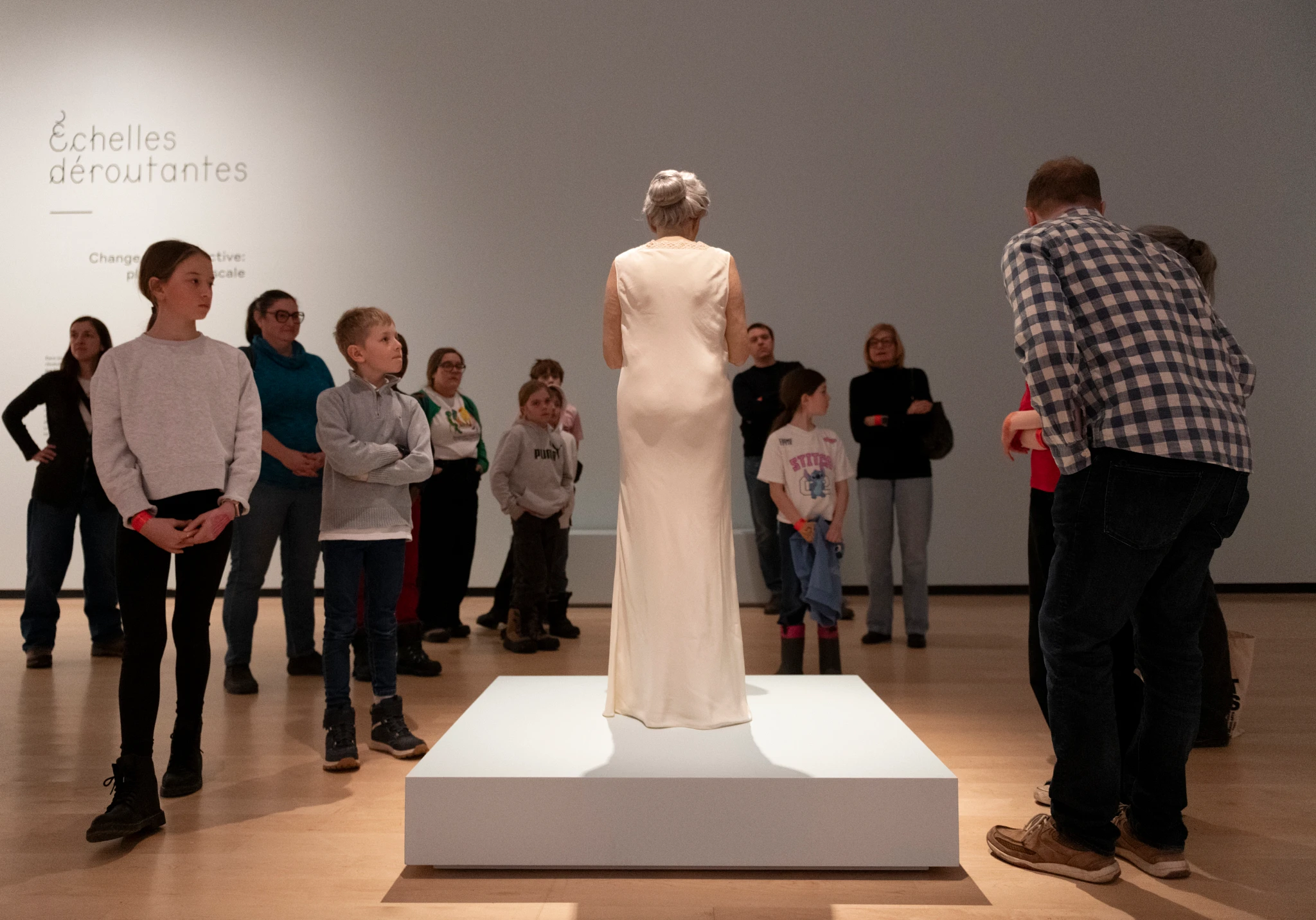 Family tour of the exhibition in front of Sam Jinks' work Woman and Child