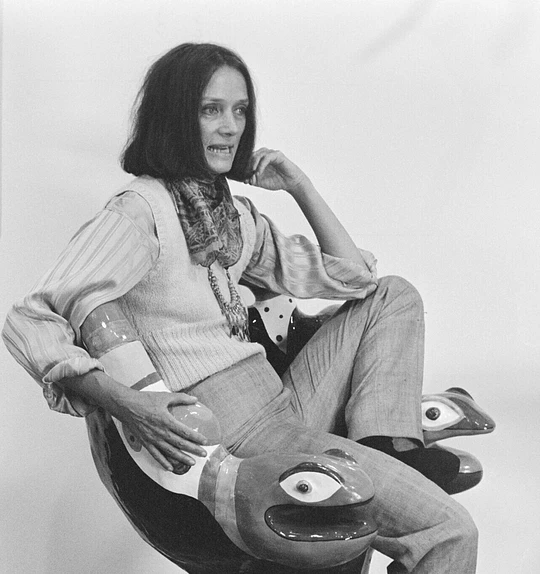 Niki de Saint Phalle sitting on one of her armchairs during the installation of her retrospective at the Centre Pompidou