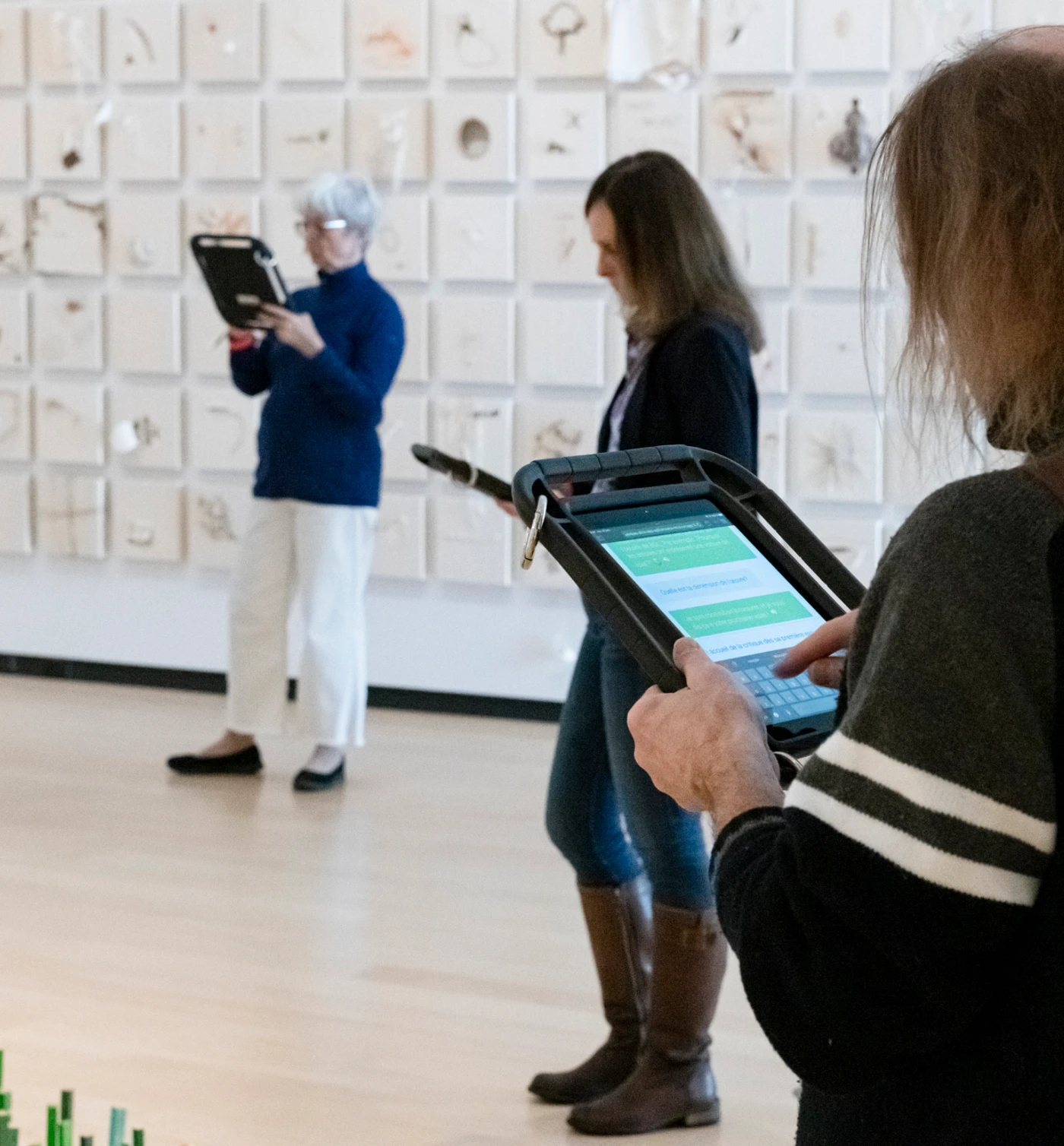 Des visiteurs interagissent avec l'agent conversationnel dans une salle du Musée national des beaux-arts du Québec.