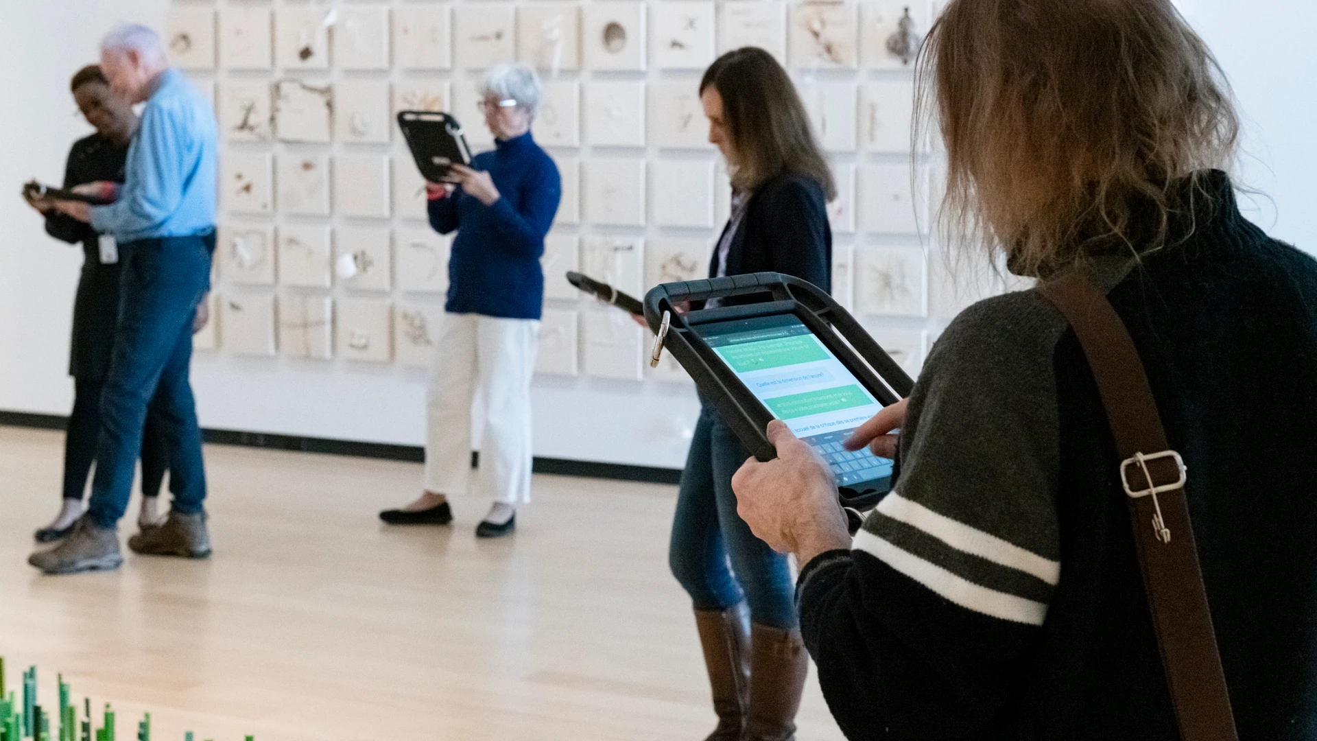 Des visiteurs interagissent avec l'agent conversationnel dans une salle du Musée national des beaux-arts du Québec.