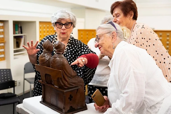 Trois femmes autour d'une sculpture pour le projet Perspectives.