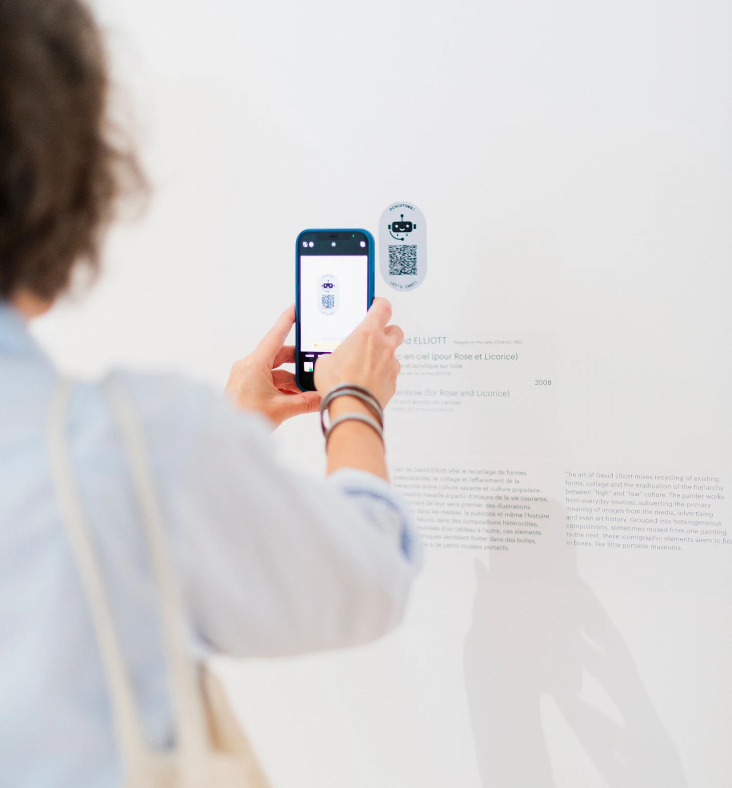Une visiteuse interagit avec l'agent conversationnel dans une salle du Musée national des beaux-arts du Québec.