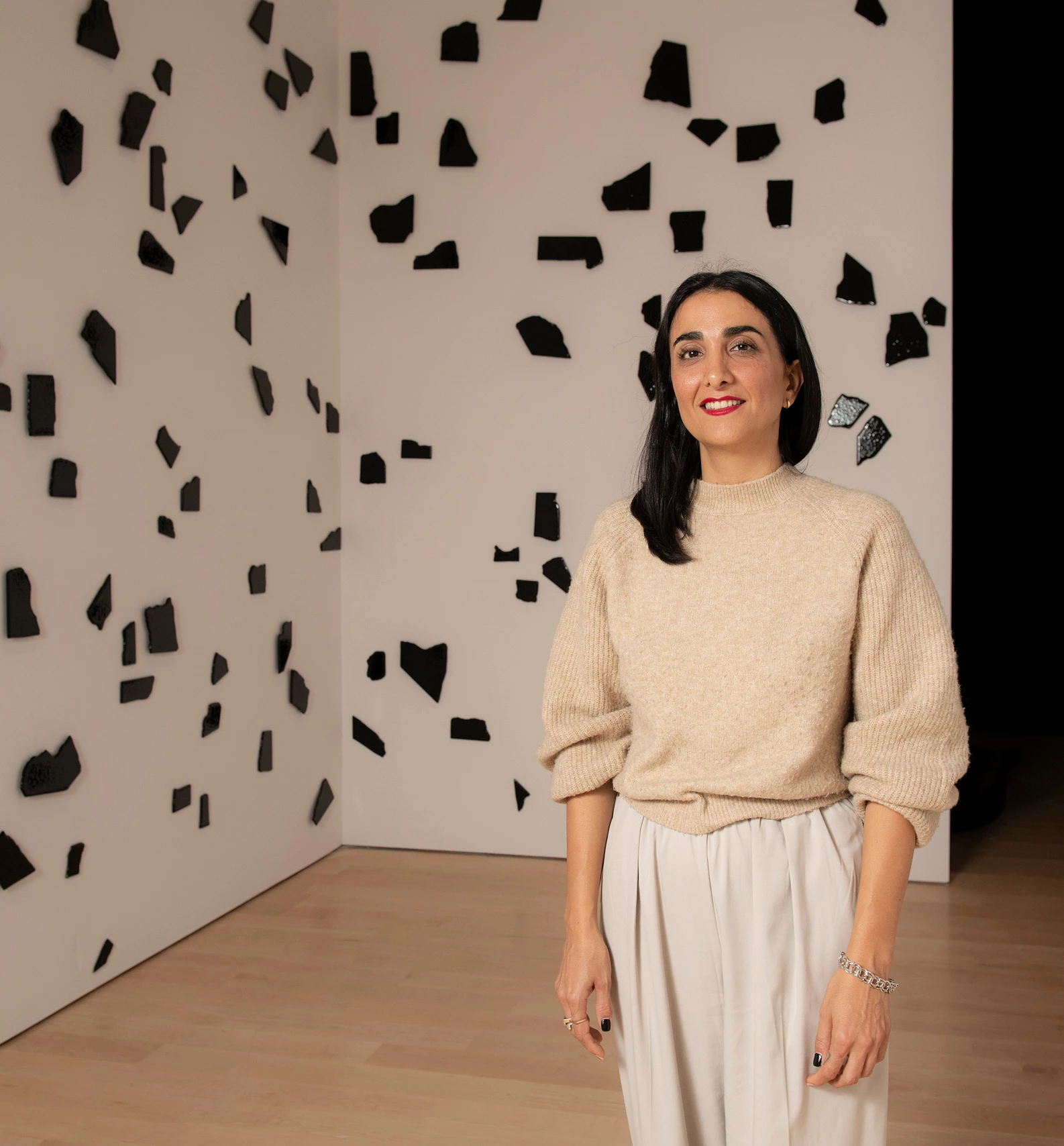 Anahita Norouzi, lauréat du prix en arts actuels 2023, posant devant son œuvre au Musée national des beaux-arts du Québec.